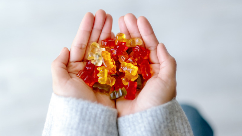 A kid holding CBD gummies with two hands