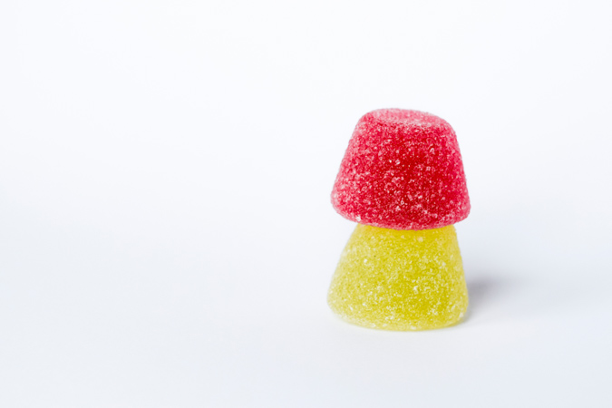 Two pieces of CBD gummies on top of each other in a white background