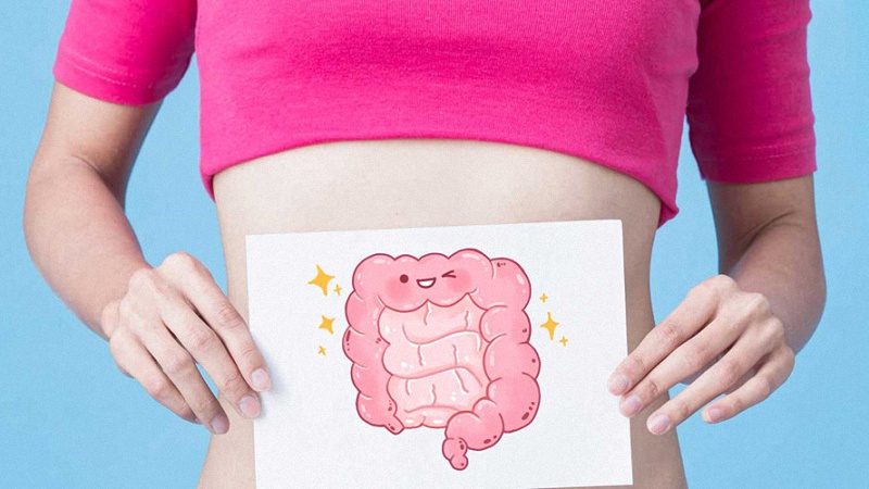 Woman holding drawing of happy stomach in front of her