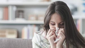 A lady sneezing with allergy