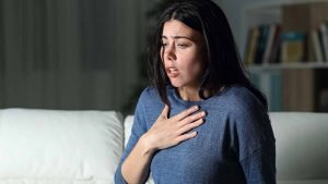 Woman with hand on chest having a panic attack