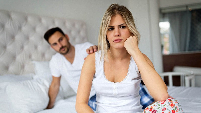 Young unhappy couple in bed having problems and crisis