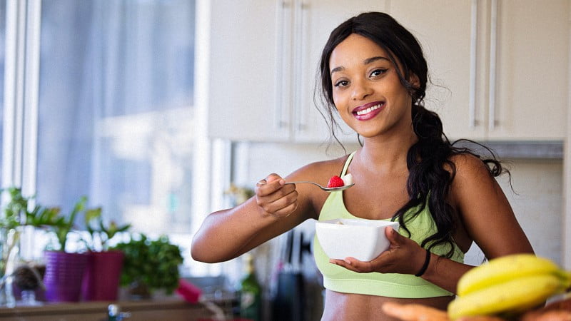 Woman in workout clothes eating a healthy meal