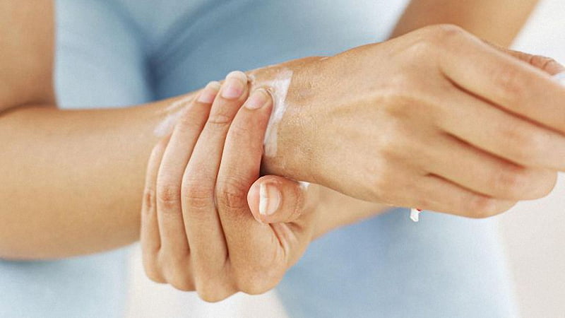 A person applying CBD cream on painful wrist