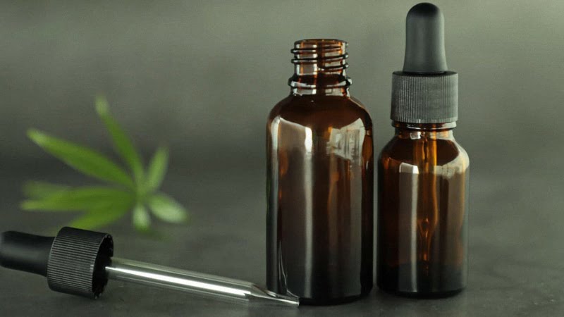 CBD Oils in Bottle with Hemp Leaf In the Background