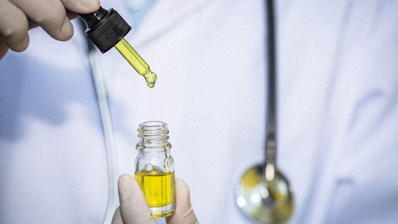 A doctor is holding a CBD Oil bottle