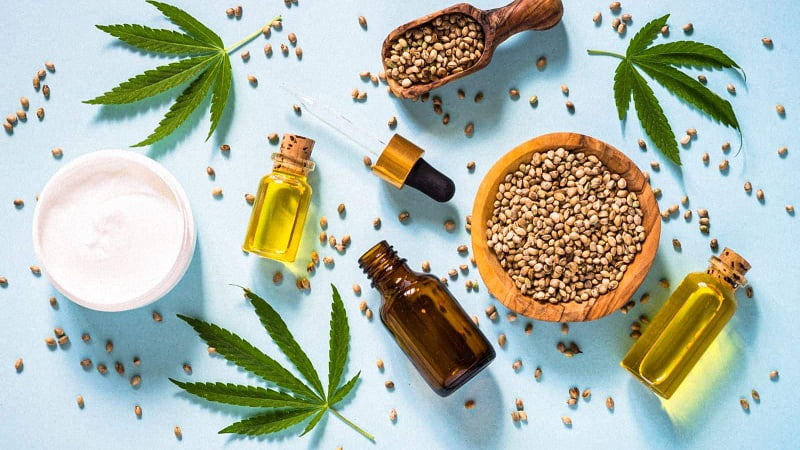 CBD Products and Hemp Flower with seeds on blue background