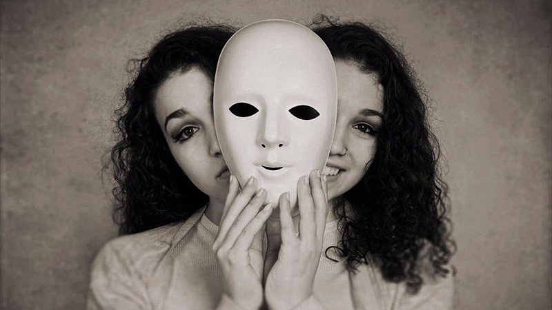 Woman with Bipolar Disorder Holding a Mask in Gray Color