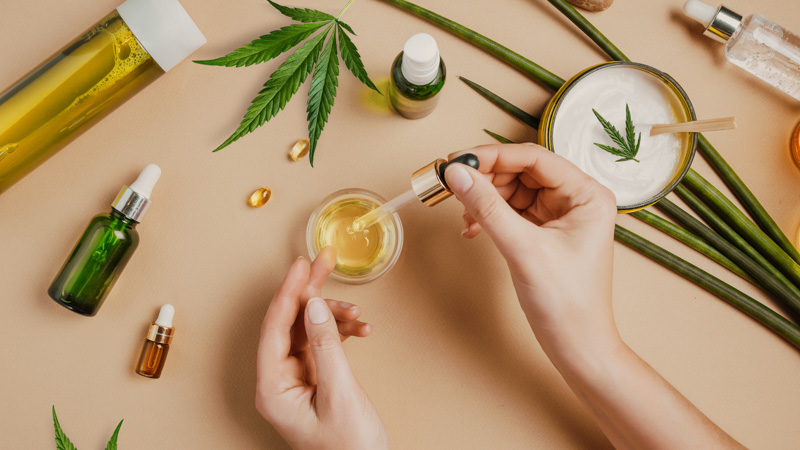 CBD Products With Hemp Leaf in a Beige Background