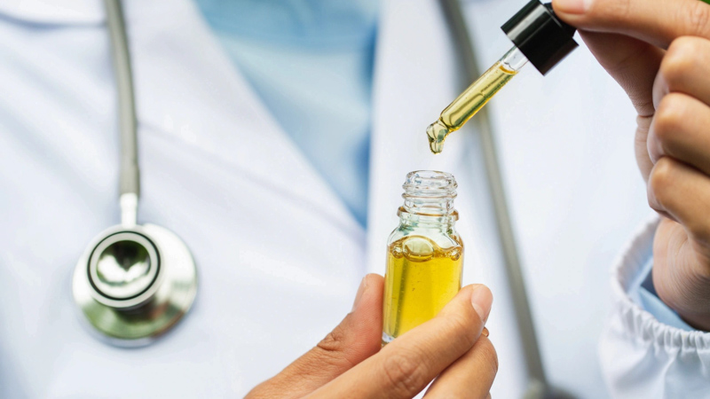 A Doctor With Stethoscope Holding CBD Oil 